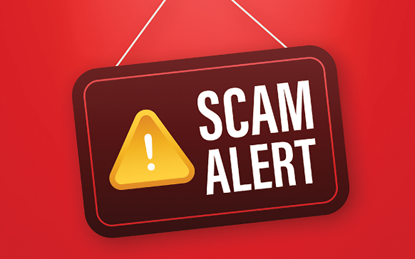 A sign with yellow caution symbol reading "Scam Alert"